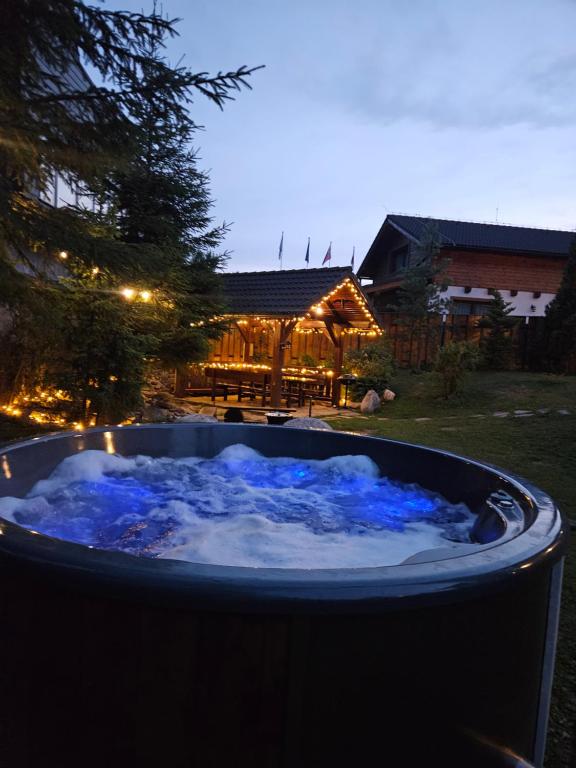 a jacuzzi tub with blue lights in a yard at Chata pod Chopkom in Tale