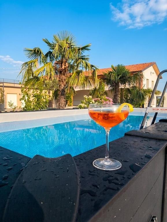 a drink sitting on a table next to a swimming pool at Corte Tegassa Pool & Spa in Pinerolo