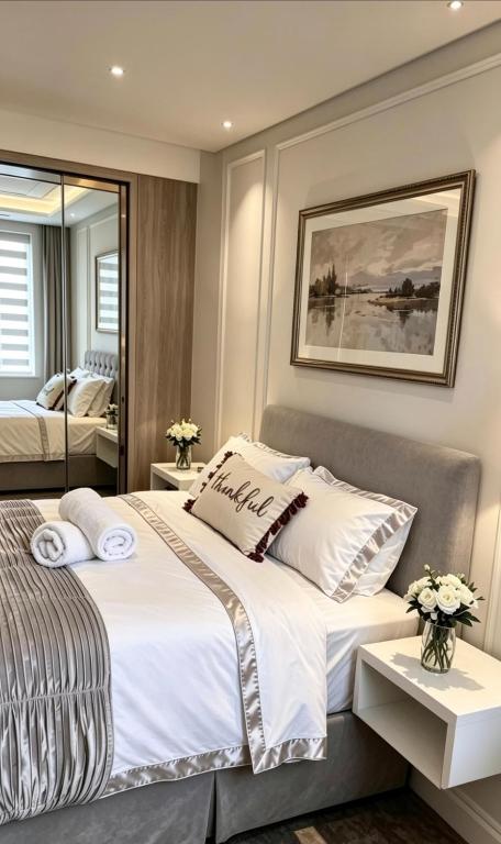 a bedroom with a large white bed and a mirror at The Dorking Hideaway B&B in Dorking