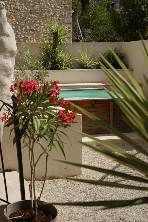 a potted plant and a bench in a garden at Le Loft in Sainte Anastasie - Aubarne