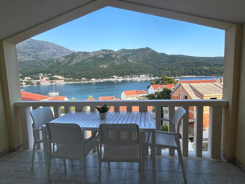 a table and chairs on a balcony with a view of the water at Blue Wave Apartments - Adriatic in Slano