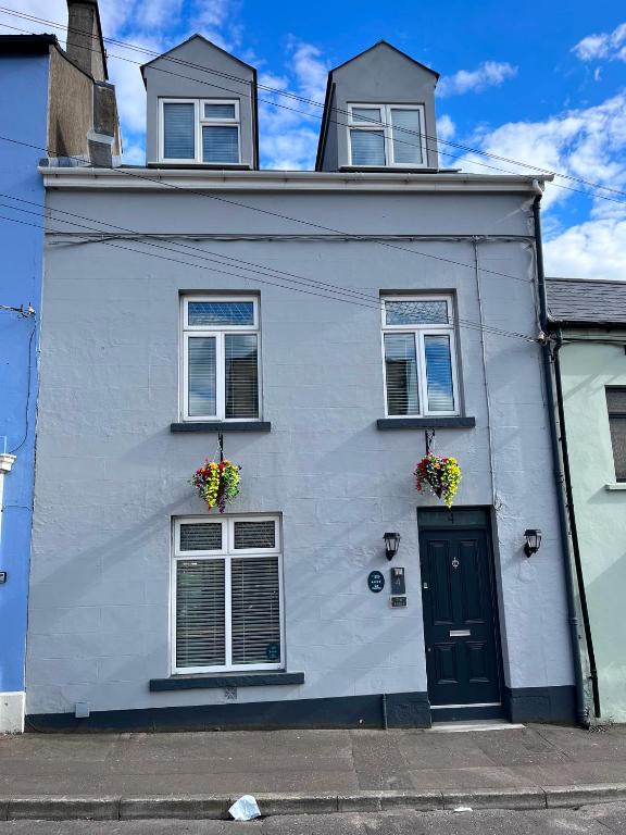 a white house with two windows and a door at The Earls in Newry