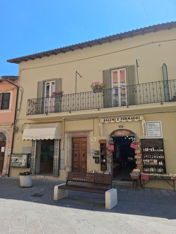 a building with a store with a balcony on top at Domus Cassia in Cascia