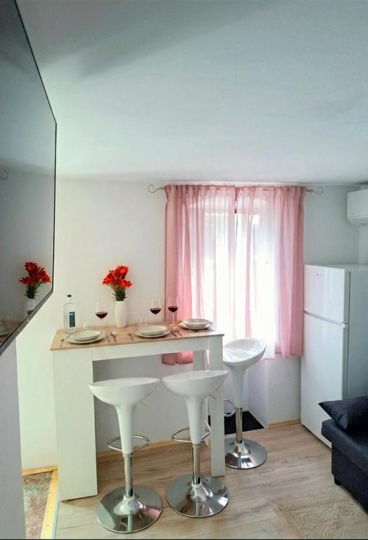 a small kitchen with a table and two stools at C&M Studio Apartment in Rijeka
