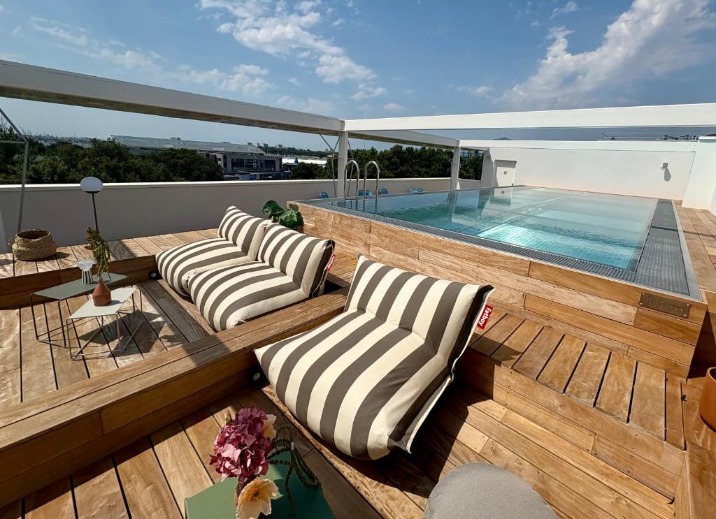 a deck with two lounge chairs and a swimming pool at Sweetly La Rochelle in La Rochelle