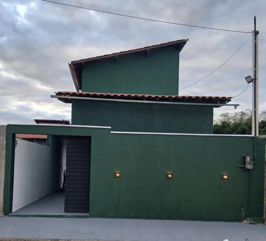 a green building with a garage at Loft urbano in Martins