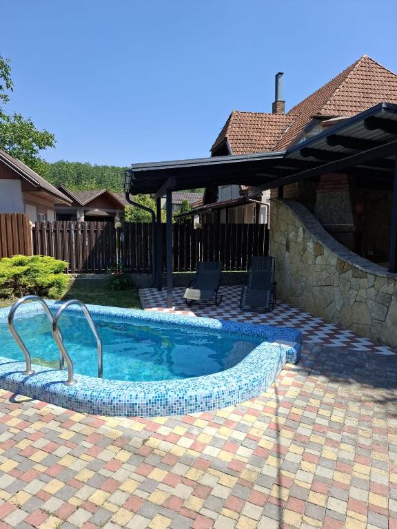 a swimming pool in a yard with an umbrella at Outbreak 3 bedroom house with outdoor pool, BBQ and dining in Pirita in Corjova