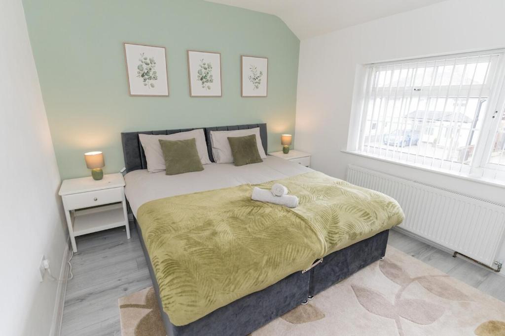 a bedroom with a large bed with two towels on it at Blackthorne House in Walsall