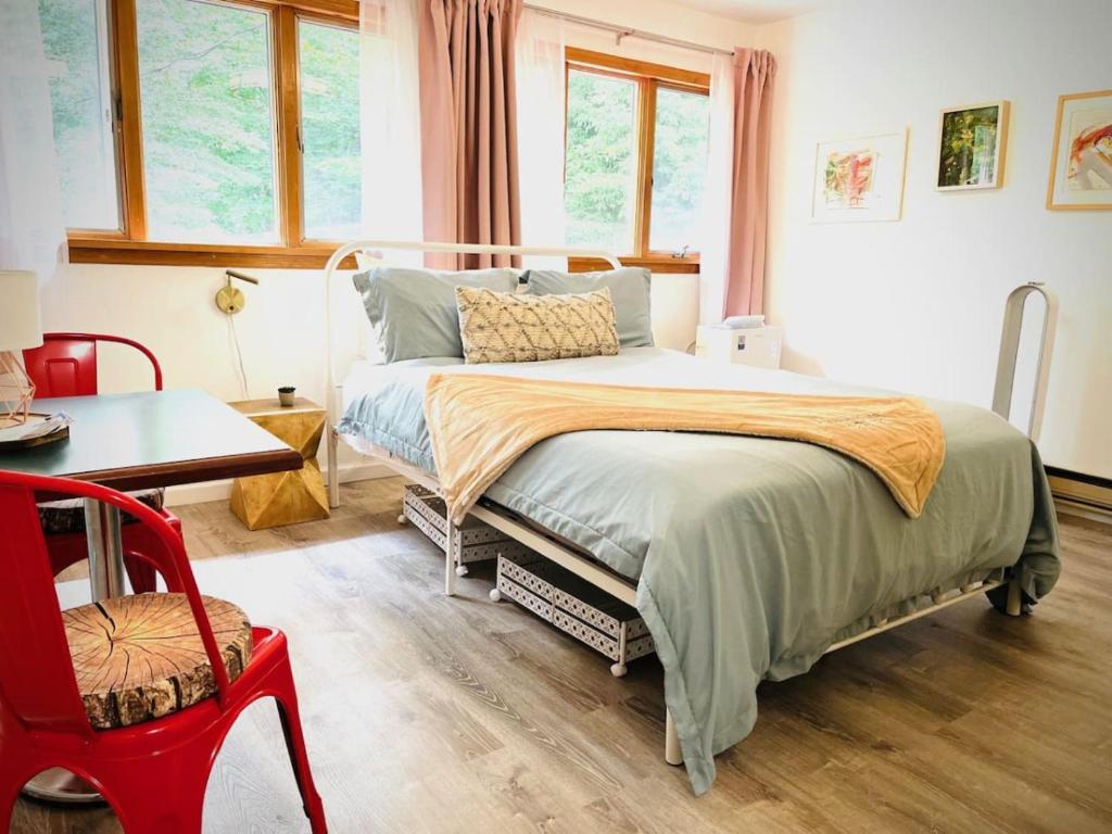 a bedroom with a bed and a table and a chair at Catskills The Bohemian Dream in Shandaken
