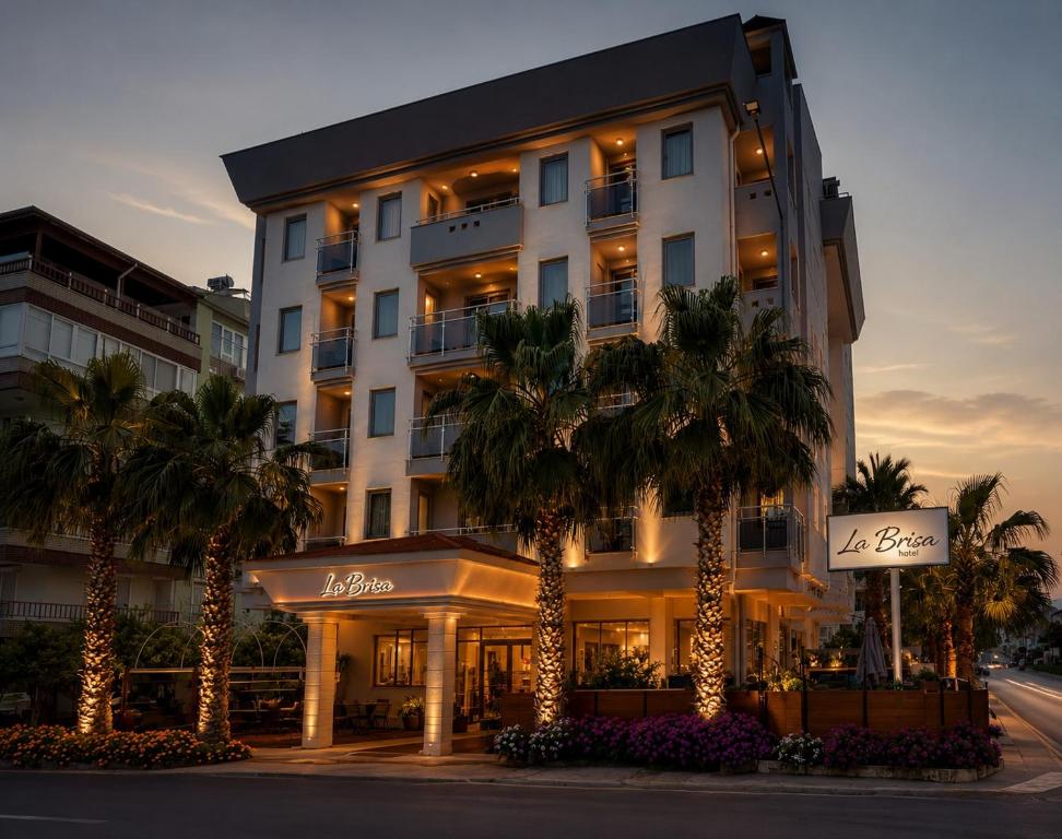 a hotel with palm trees in front of a building at La Brisa Hotel in Antalya