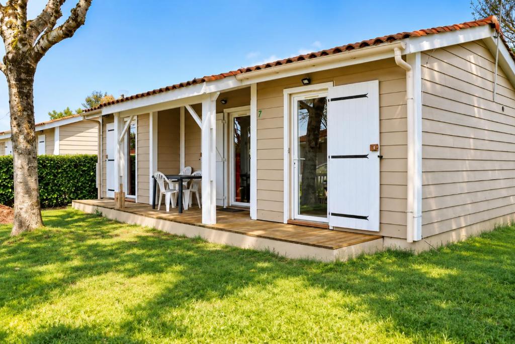 a house with a porch and a deck at Chalet Mauzac- Piscine- Domaine Paisible in Rivières