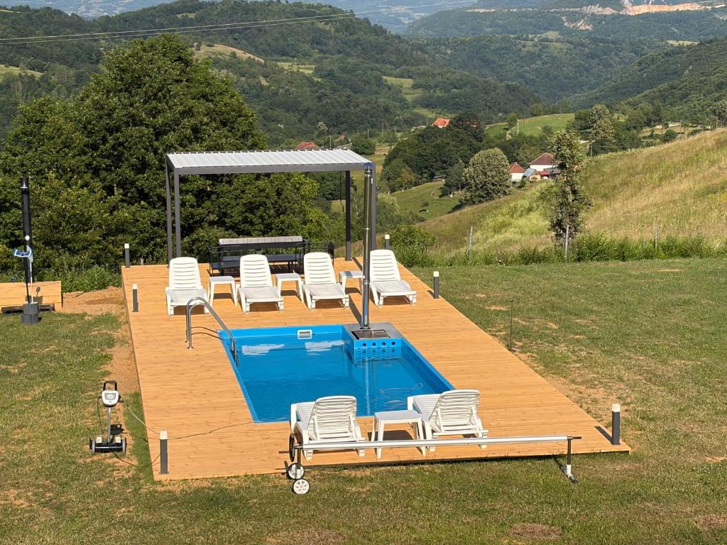 eine Terrasse mit Pool und Stühlen in der Unterkunft ATETA Tiny House in Dealu Mare