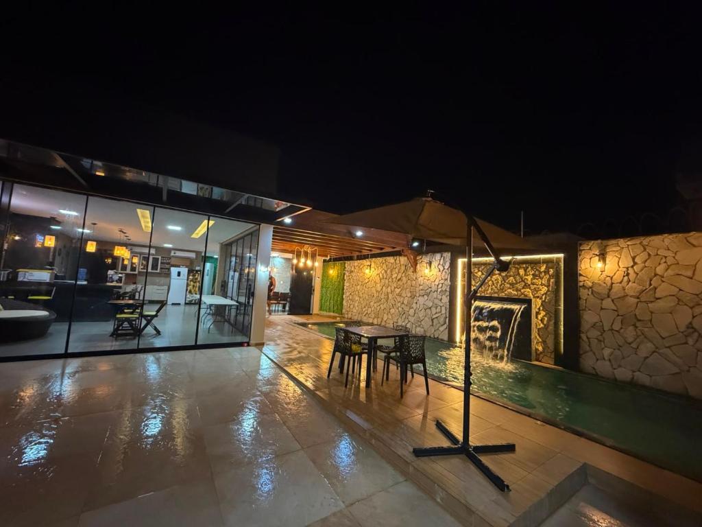 a room with a table and a fireplace at night at Casa Pé no Sal in Salinópolis