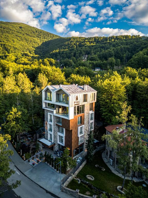Luftaufnahme eines Gebäudes mit einem Hügel im Hintergrund in der Unterkunft Pine Hotel & Spa Brezovice in Brezovica