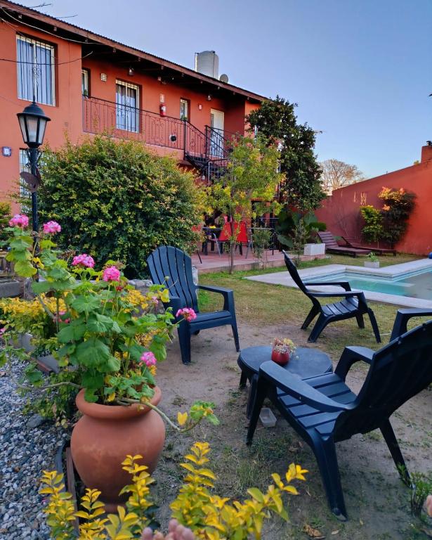 a yard with chairs and a table and flowers at La caballeriza departamentos in Alta Gracia