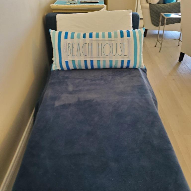 a bed with a pillow and a back house at 1315 Pelican Watch Villas-Beachfront & Amenities - on Sale in Seabrook Island