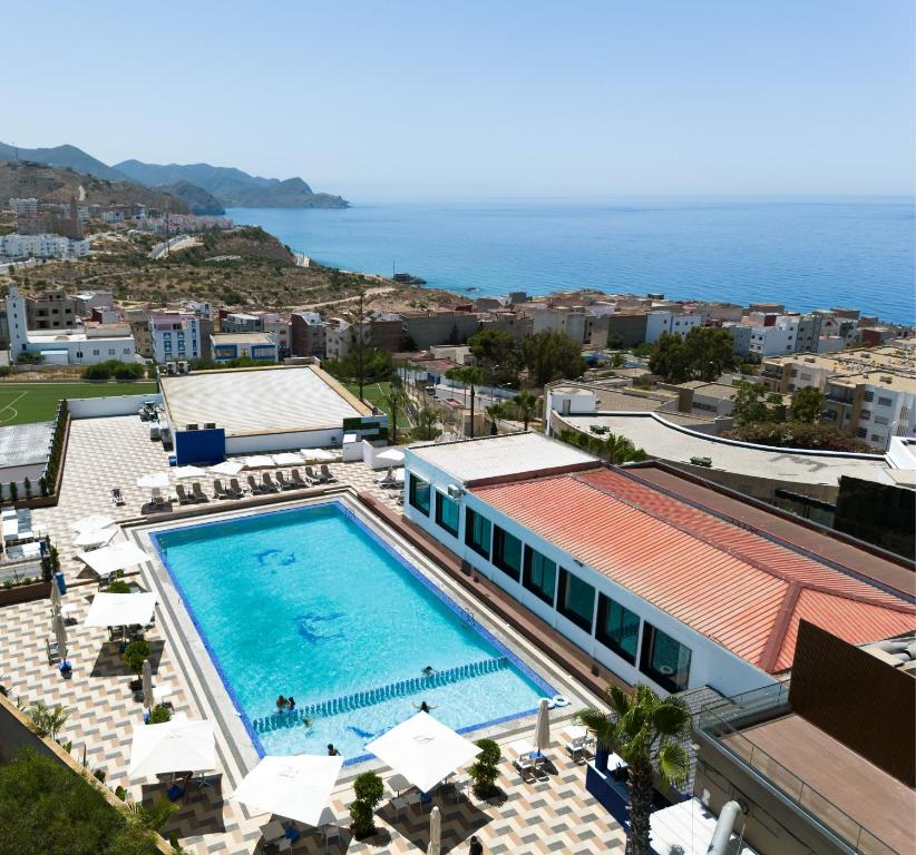 an overhead view of a swimming pool and the ocean at Mira Palace Hotel in Al Hoceïma