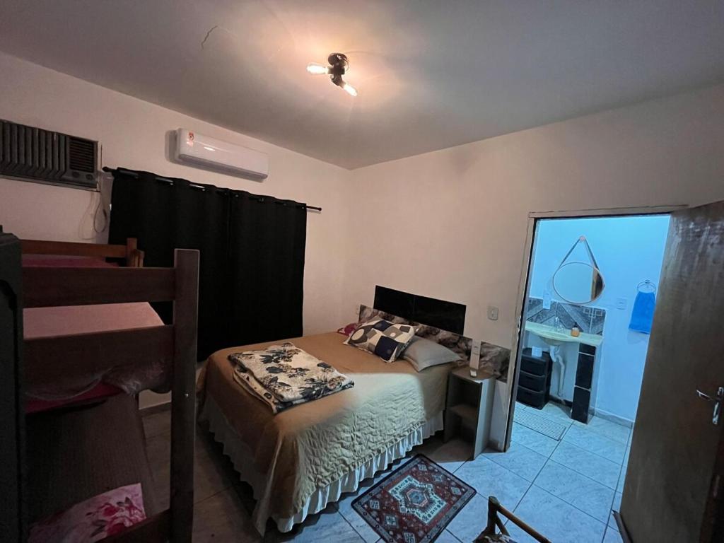 a small bedroom with a bed and a window at Loft D Mobiliado, individual com ar condicionado e garagem privada in Dourados