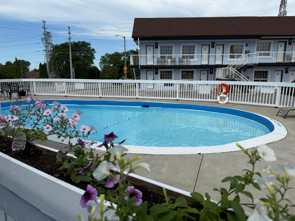 a swimming pool in front of a house at Falls Lodge by the Falls (Formerly Knights Inn) in Niagara Falls