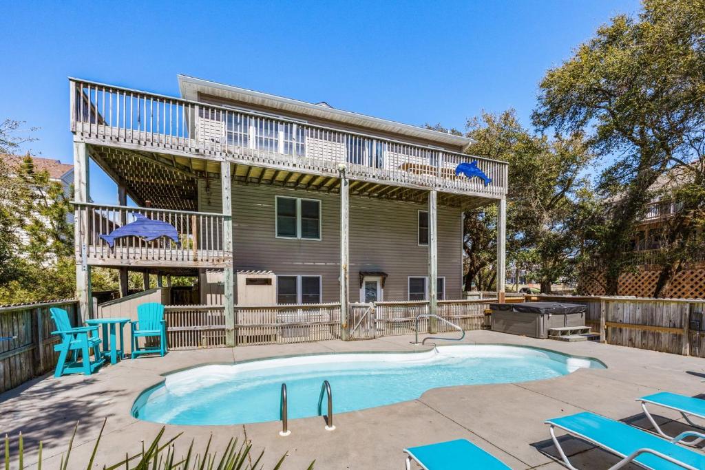 a house with a swimming pool and blue chairs at 2020 - Merryweather in Sanderling