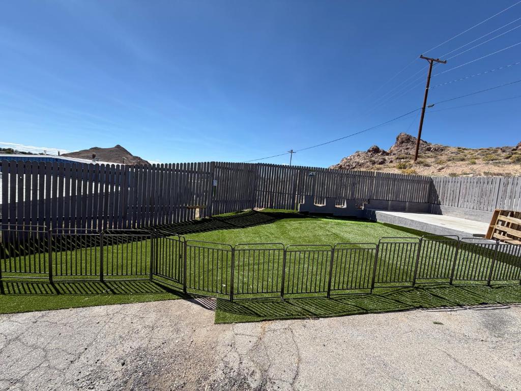 a fence with green grass in a parking lot at Dream Inn in Tonopah