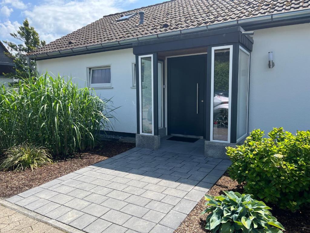 a house with a black door and a patio at Haus Blumenglück 2.0 in Herscheid