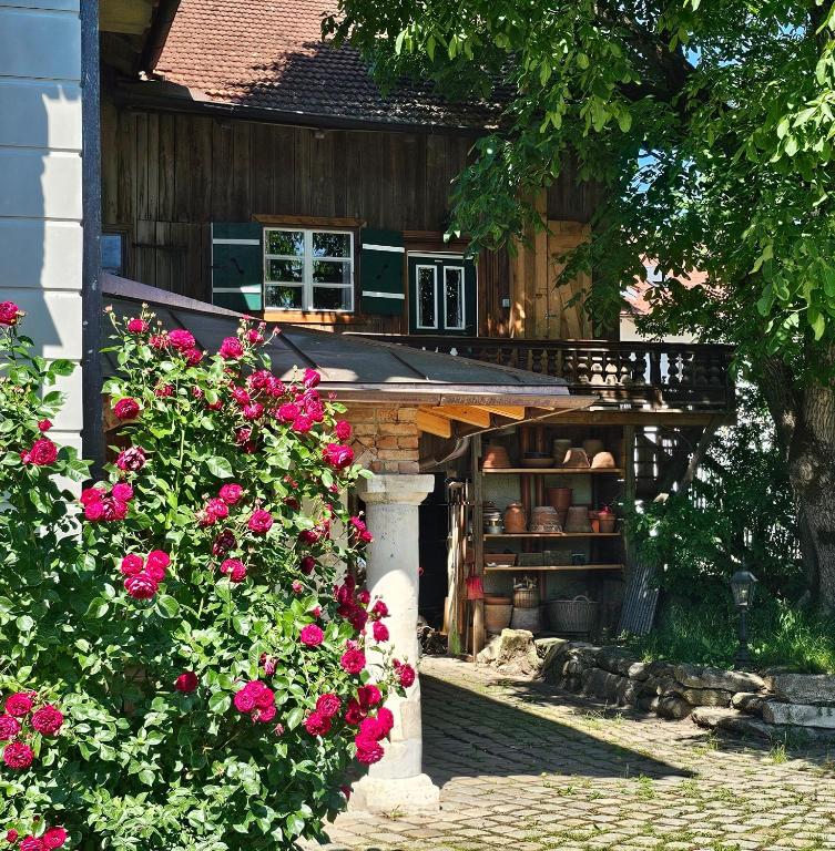 a house with a shelf with flowers in front of it at Nusseckerl Eberloh in Halfing