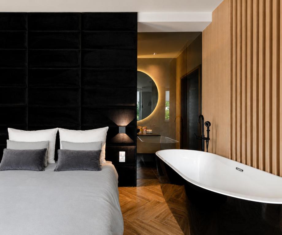 a bedroom with a large bed and a bath tub at LupoApartments z Klimatyzacją do wyboru z Jacuzzi Pole Dance Parking Dostęp na Kod in Łódź