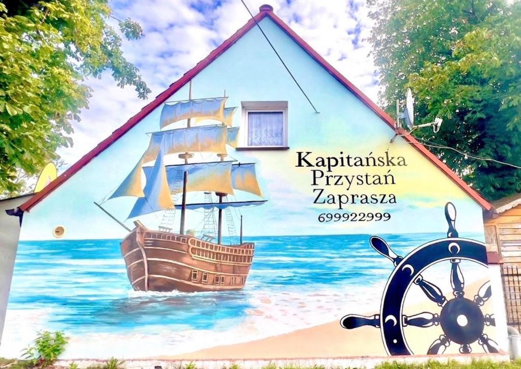 a mural of a ship on the side of a building at Kapitańska Przystań in Chłopy