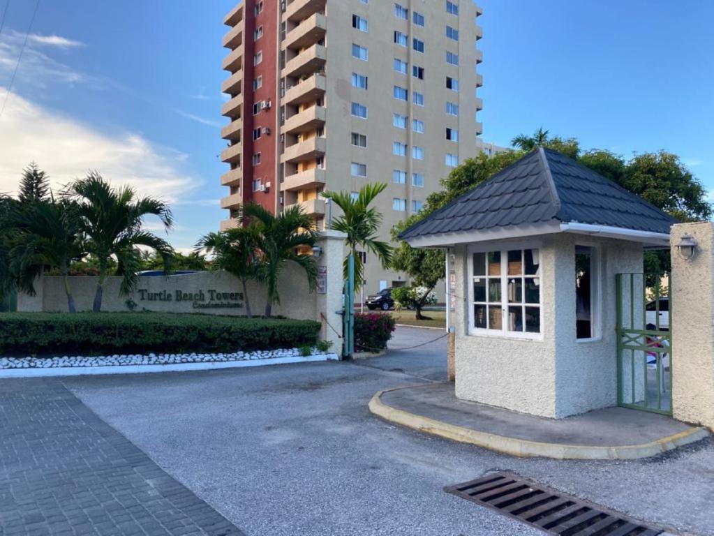 a small building in front of a tall building at Beach-side condos at Turtle Beach Towers in Ocho Rios