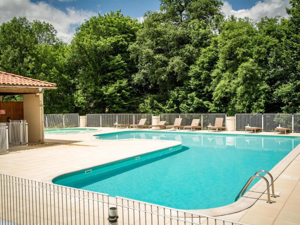 a swimming pool with chairs and a fence at Lac Bleu nr 19 in Lacapelle-Marival