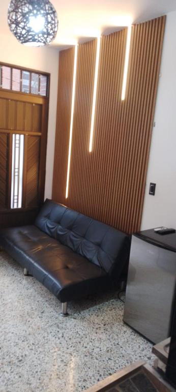 a leather couch in a room with a television at Apartamento C&B in Bello