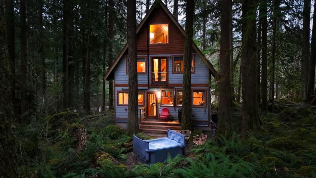 a small house in the woods with a blue chair at Treetop Hideaway, Sleeps 2 in Glacier