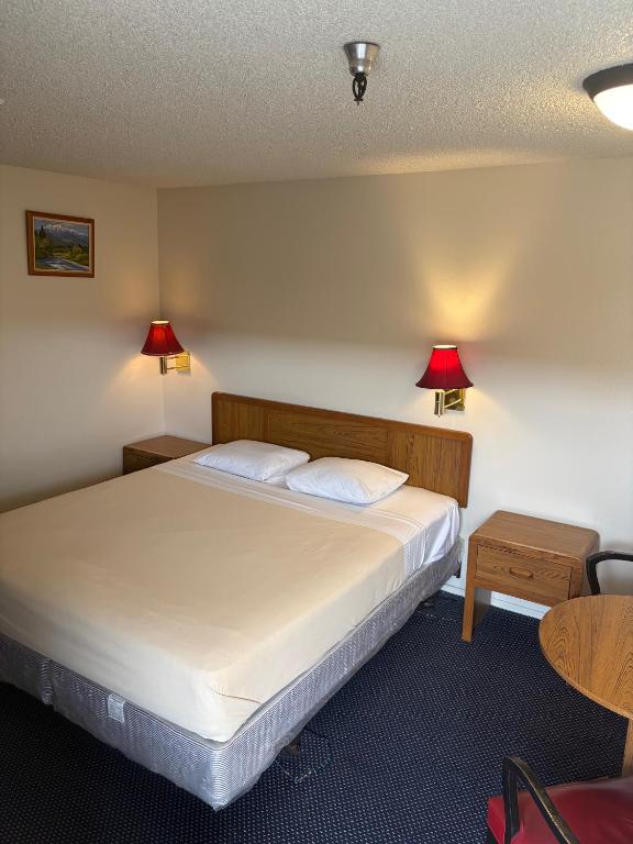 a bedroom with a bed with two lamps on the wall at Townhouse Motel- Alhambra-South Pasadena-San Marino in Alhambra