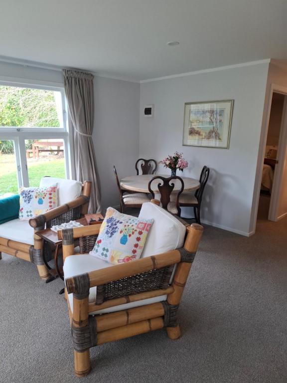 a room with chairs and tables and a window at Among The Tuii in Katikati