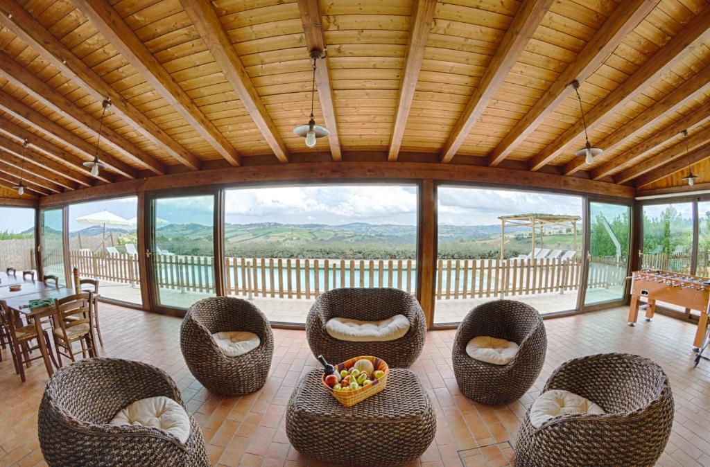 salon z wiklinowymi krzesłami i stołem w obiekcie Villa le Vigne w mieście Loro Piceno