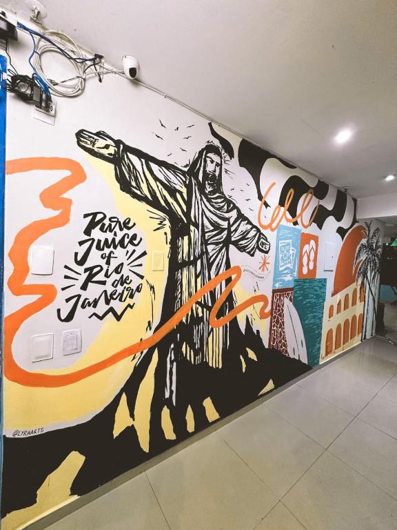 a wall with a large painting of a man at Hostel Princess Copacabana in Rio de Janeiro
