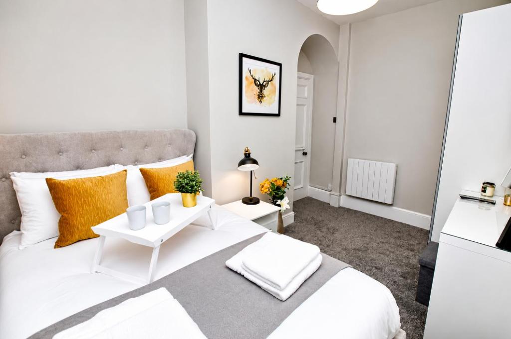 a bedroom with a large white bed with orange pillows at City Centre 1 Bed Apartment - Modern & Bright in Chester