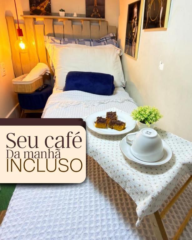 a bed with a table with a plate of food on it at micro 3 in Volta Redonda