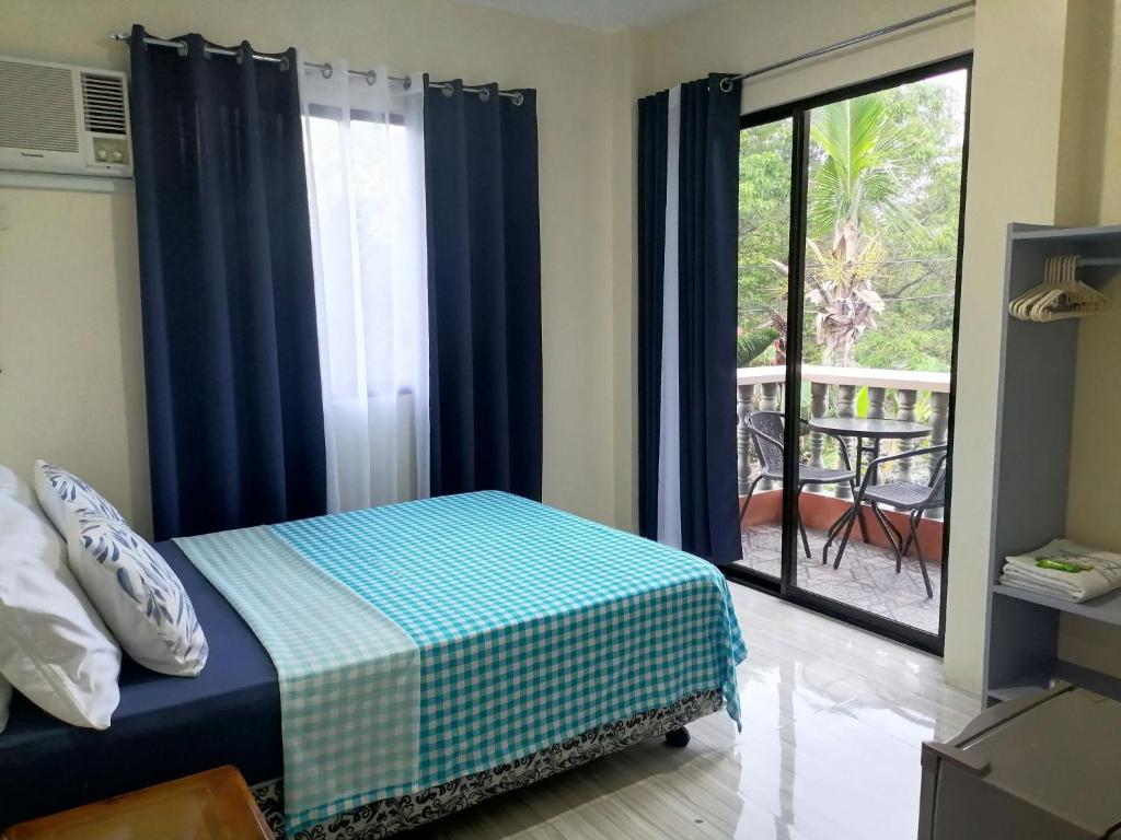 a bedroom with a bed and a view of a balcony at Solsken Guest House - Bantayan Island in Bantayan Island
