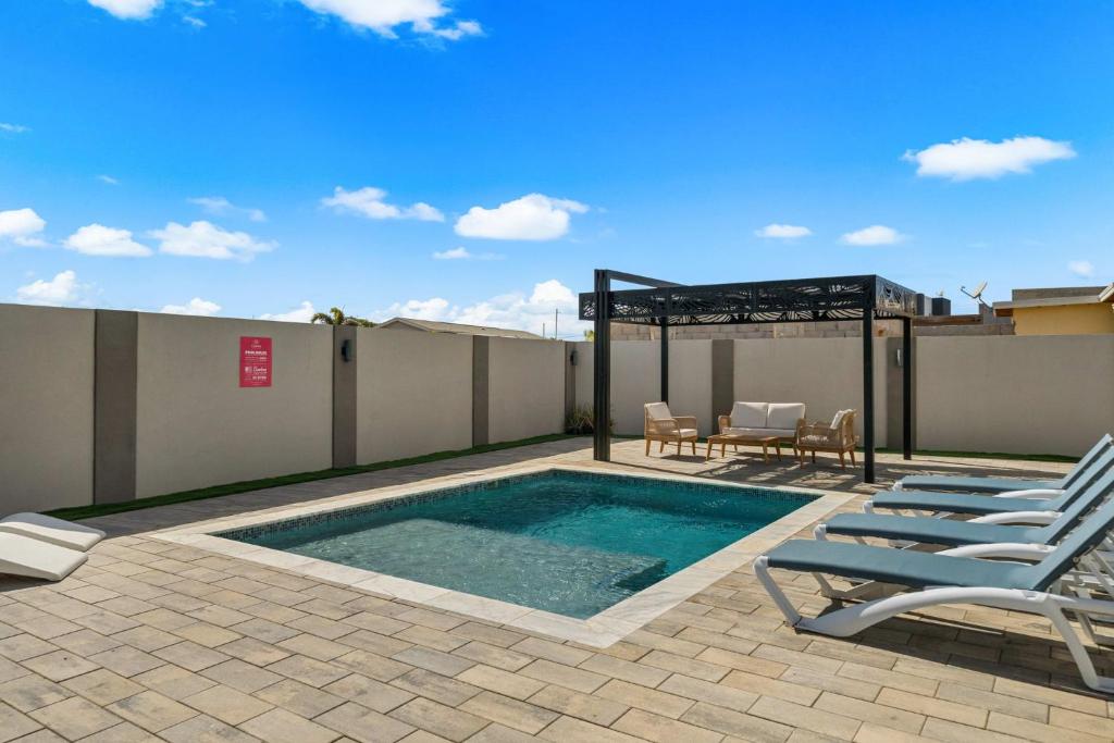 a swimming pool with chairs and a table on a roof at Monserat 33Q in Palm-Eagle Beach