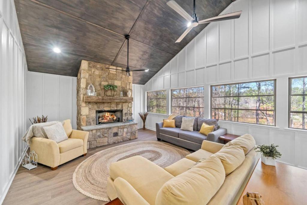 a living room with a couch and a fireplace at Lakeside Lodge on Bluegill- Arcade, Dock, FirePit in Eatonton