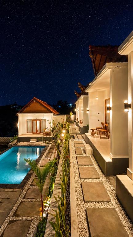 a villa with a swimming pool at night at The Tamarin Villas in Nusa Penida