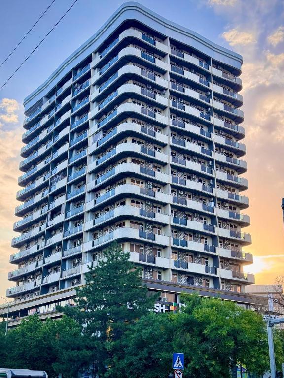 a tall building with trees in front of it at Sayram in Yunusobod