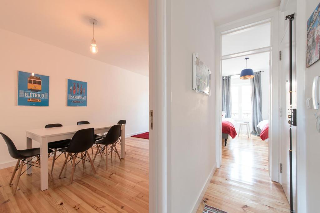 a dining room and living room with a table and chairs at Casa Eclea Lisbon Great Apartment with terrace in Lisbon