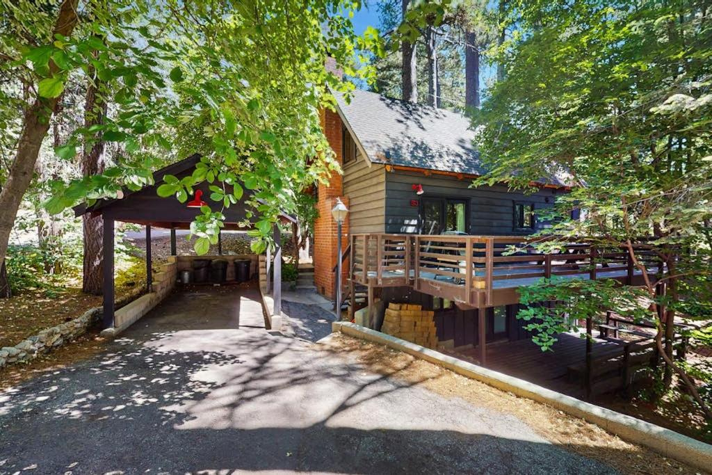 a log cabin with a porch in the woods at Wooded Comfort in Lake Arrowhead