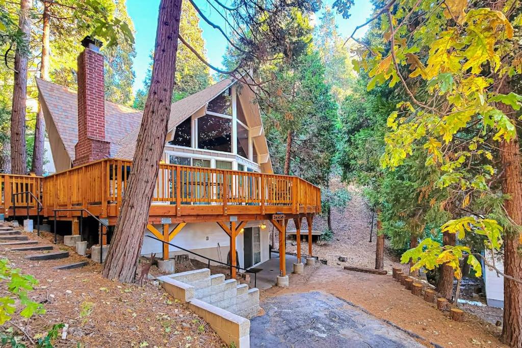 ein Haus mit einer Holzterrasse im Wald in der Unterkunft Pinecrest Paradise in Crestline