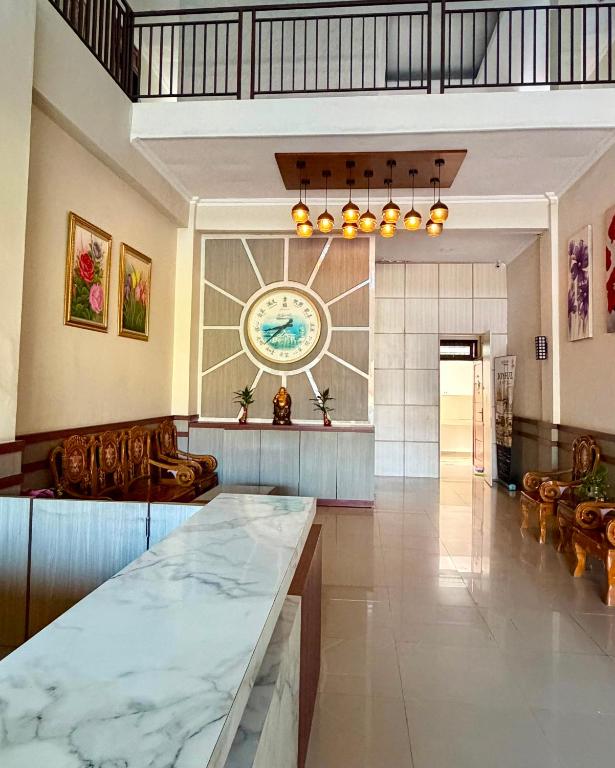 a large lobby with a large clock on the wall at Joyful Hotel in Tanjungpandan