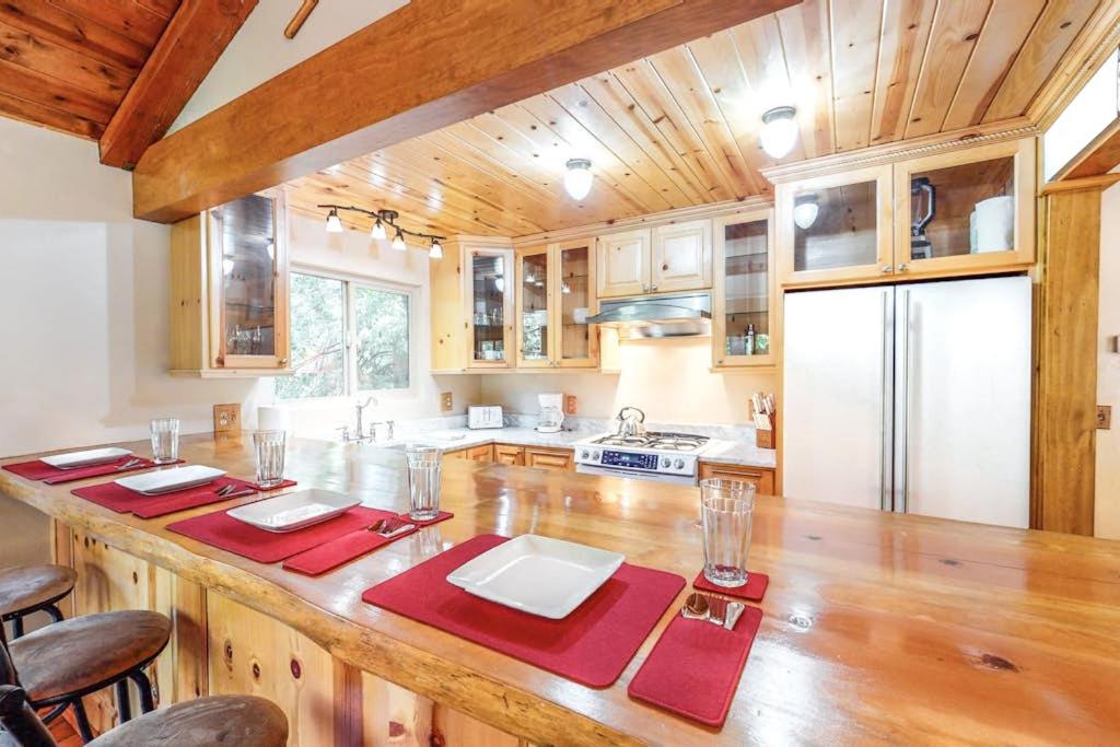 a kitchen with a large wooden island with red napkins at Sky High Cabin in Crestline