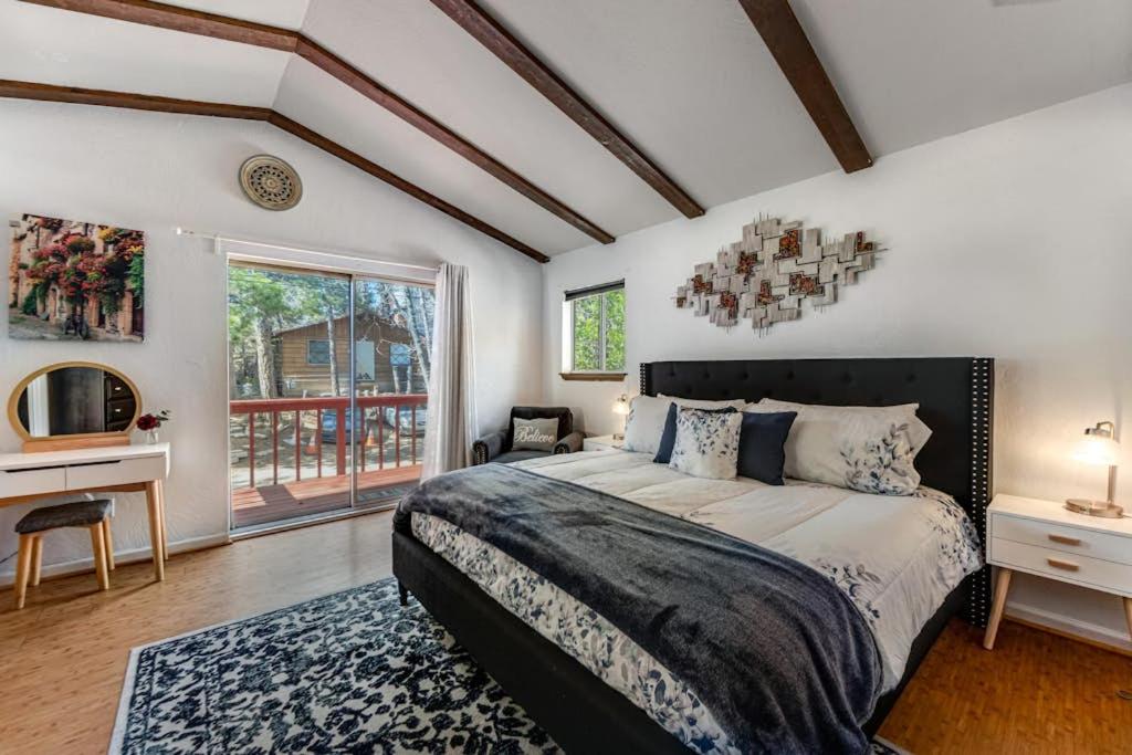 a bedroom with a bed and a desk and a window at Blue Bird Beauty in Running Springs